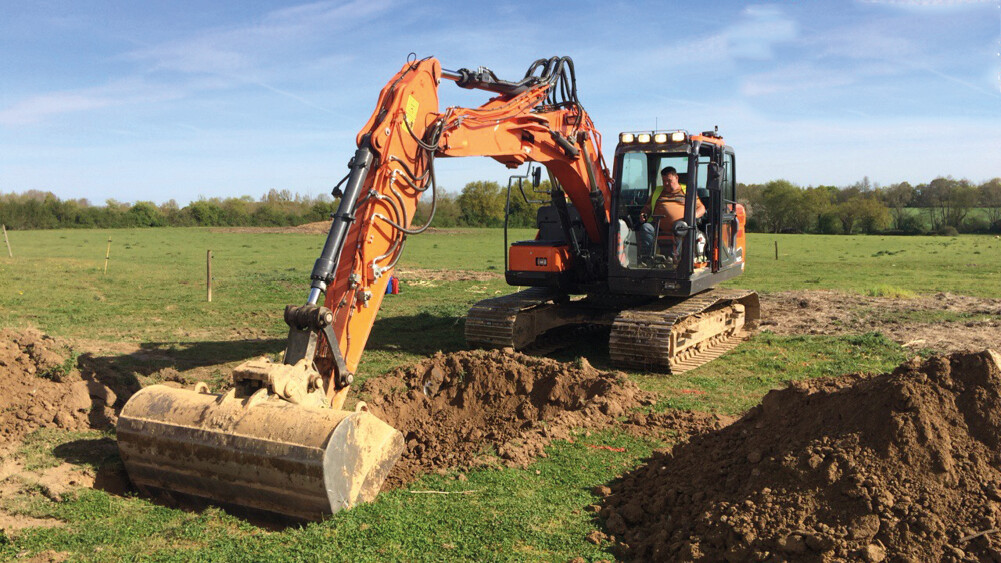 Excavator digging trench, showing ground work for infrastructure projects using AP Sensing fiber optic detection systems Excavator digging trench, showing ground work for infrastructure projects using AP Sensing fiber optic detection systems