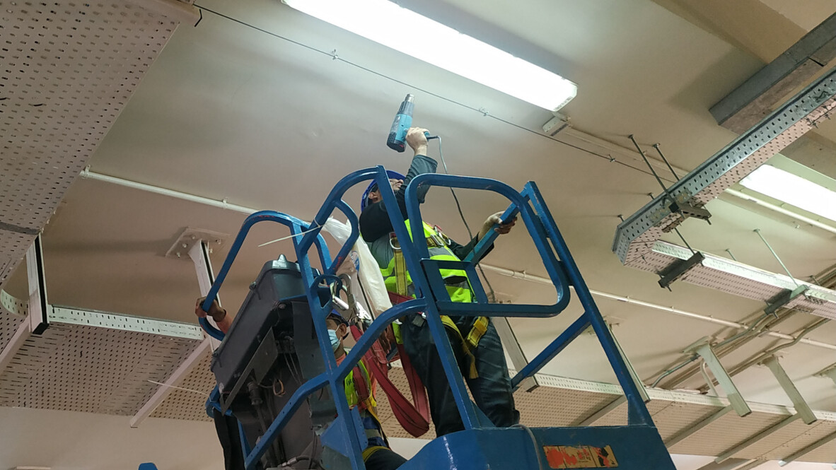 Workers installing/maintaining infrastructure near cable trays potentially monitored by AP Sensing fiber optic sensing solutions Workers installing/maintaining infrastructure near cable trays potentially monitored by AP Sensing fiber optic sensing solutions