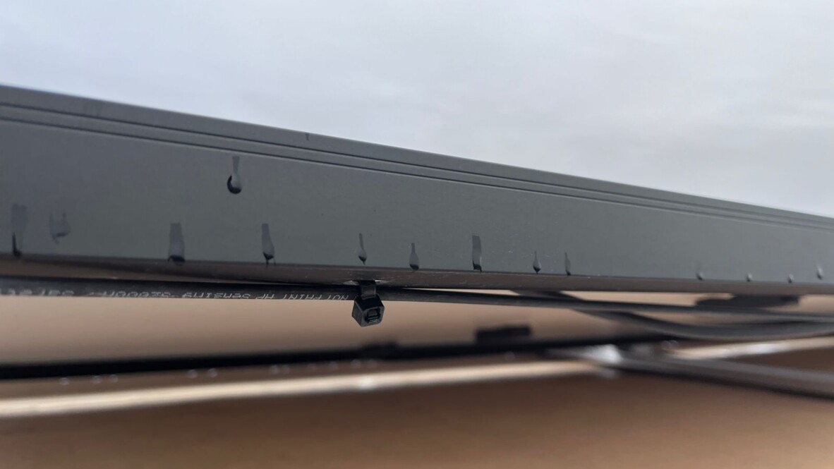 The fiber optic cable zigzags between each row of solar panels AP Sensing fiber optic sensing system installation detail showing secured cables