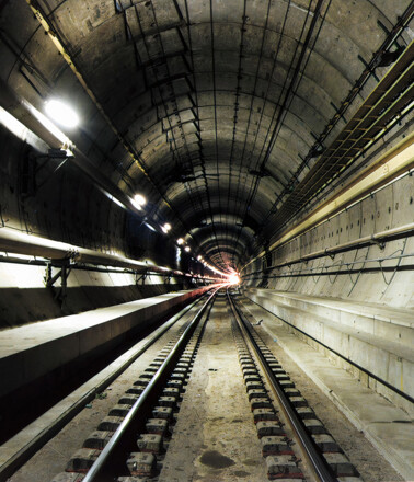 © Eurotunnel Dark subway tunnel with tracks, illustrating infrastructure monitored by AP Sensing fiber optic solutions
