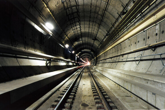 Dark subway tunnel with tracks, illustrating infrastructure monitored by AP Sensing fiber optic solutions Dark subway tunnel with tracks, illustrating infrastructure monitored by AP Sensing fiber optic solutions