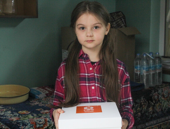 Young girl holding a white box with an orange logo sticker Young girl holding a white box with an orange logo sticker