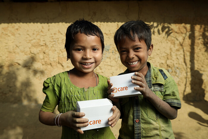 Lachende Kinder halten care-Pakete, symbolisieren Sicherheit für eine bessere Zukunft Lachende Kinder halten care-Pakete, symbolisieren Sicherheit für eine bessere Zukunft