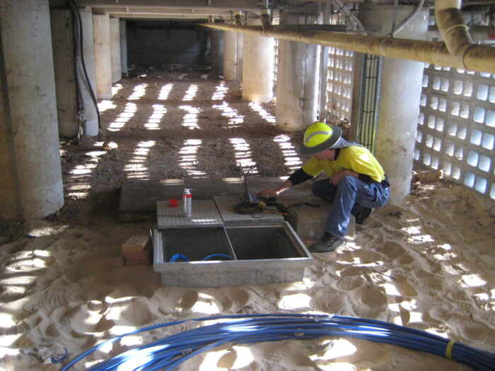 Technician connecting AP Sensing distributed temperature or acoustic sensing cables in a trench Technician connecting AP Sensing distributed temperature or acoustic sensing cables in a trench